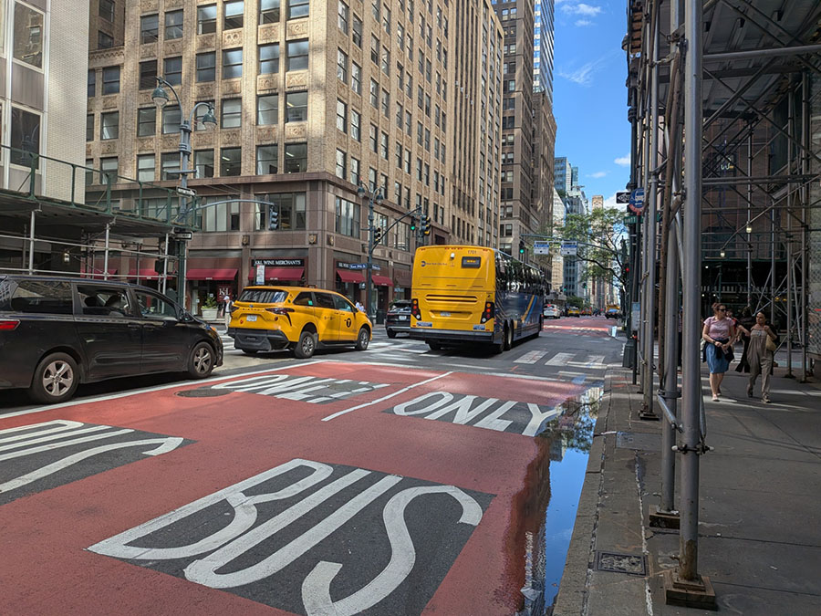 A road painted with red and text reads Bus Only