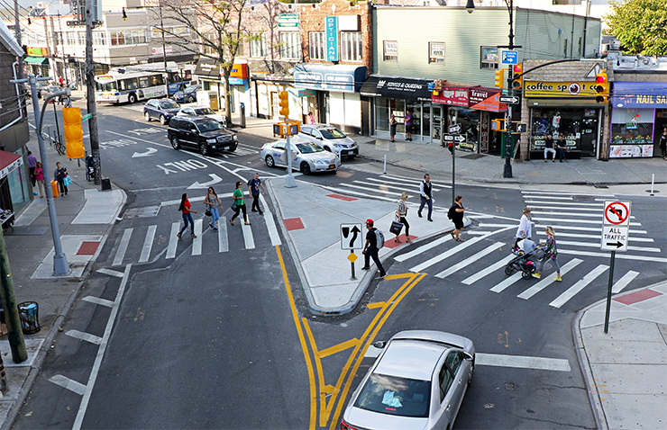 Sheepshead Bay Road and Jerome Avenue, after conditions. Pedestrians cross Sheepshead Bay Road on a new concrete triangle, reducing crossing distances and conflicts on the one-way street.