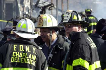 Fire Department Chaplain and Chief Fire Marshal discuss the scene.