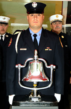 Firefighter Michael Cook rings a bell as the names of each of the 12 members who died in the 23rd Street fire are read.