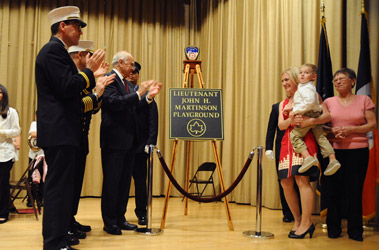 Iris Martinson (pink shirt), Jessica Martinson and 3-year-old John Patrick stand with Fire Commissioner Nicholas Scoppetta, Chief of Department Salvatore Cassano and FDNY Chaplain Reverend Stephen Harding unveil the plaque dedicating the park at P.S. 55 as the Lt. John H. Martinson Playground.