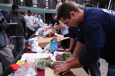 Firefighters Nick Miller and Joe Costa from Engine 202/Ladder 101 (who won the Fairway Firefighters Food Face-Off) prepare ribs for the crowd.