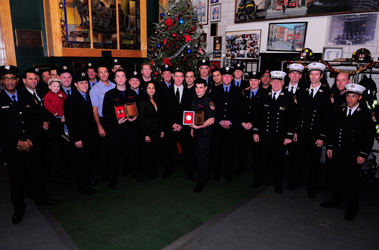 Members from Engine 39 and Ladder 16 stand with the two Liberty Mutual Firemark Award winners.