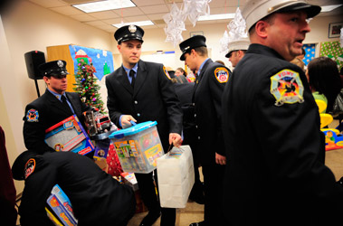 Firefighters from Engine 155/Ladder 78 help distribute the toys at the Staten Island University Hospital’s Dr. Jerome L. Finkelstein Burn Center.