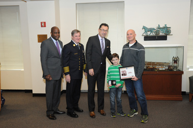 (L to R) First Deputy Commissioner Robert Turner, Chief of Department James Leonard, Fire Commissioner Daniel Nigro, Ryan Zinna and Darren Zinna. They hold the boyâ€™s new badge, naming him an Honorary Firefighter.