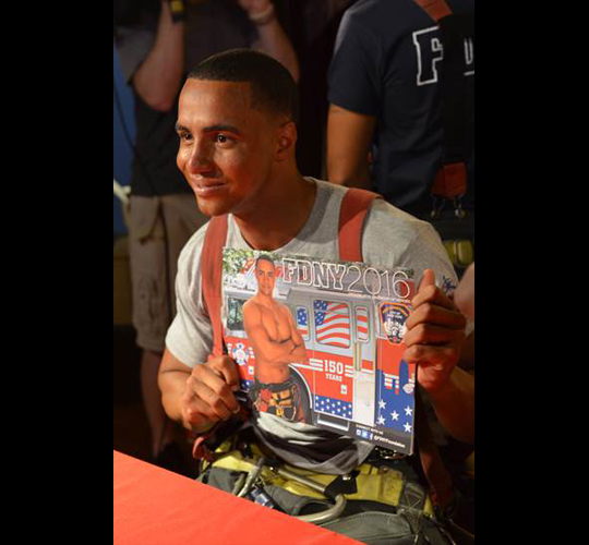 Firefighter Jamah Figaro holds his calendar picture