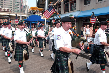 The Emerald Society Pipes and Drums Band leads the crowd to the water at the South Street Seaport to watch the blessing.
