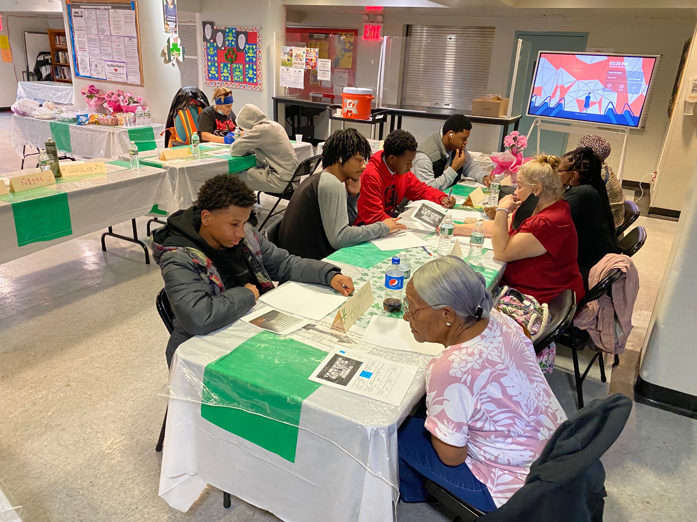 A group of young and older adults seated together asking each other questions.