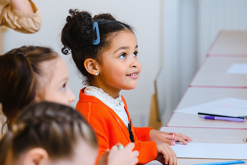 Photo of children sitting at their desks in a classroom.