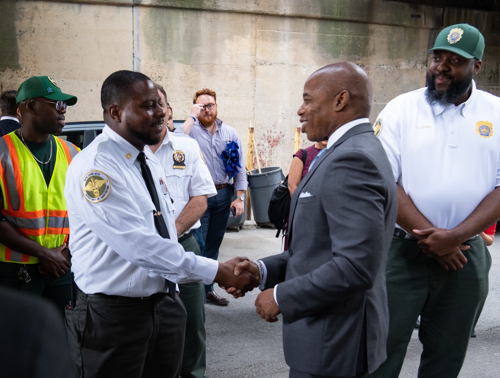 mayor Eric Adams shaking hands with a Department of Sanitation worker