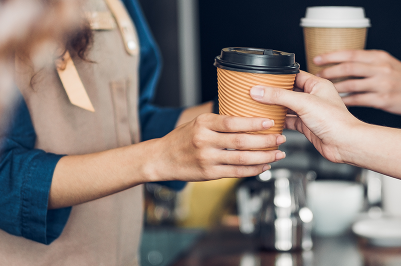 Barista hands coffee to customer
                                           