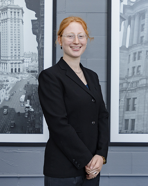 Woman smiling, wearing a black blazer.