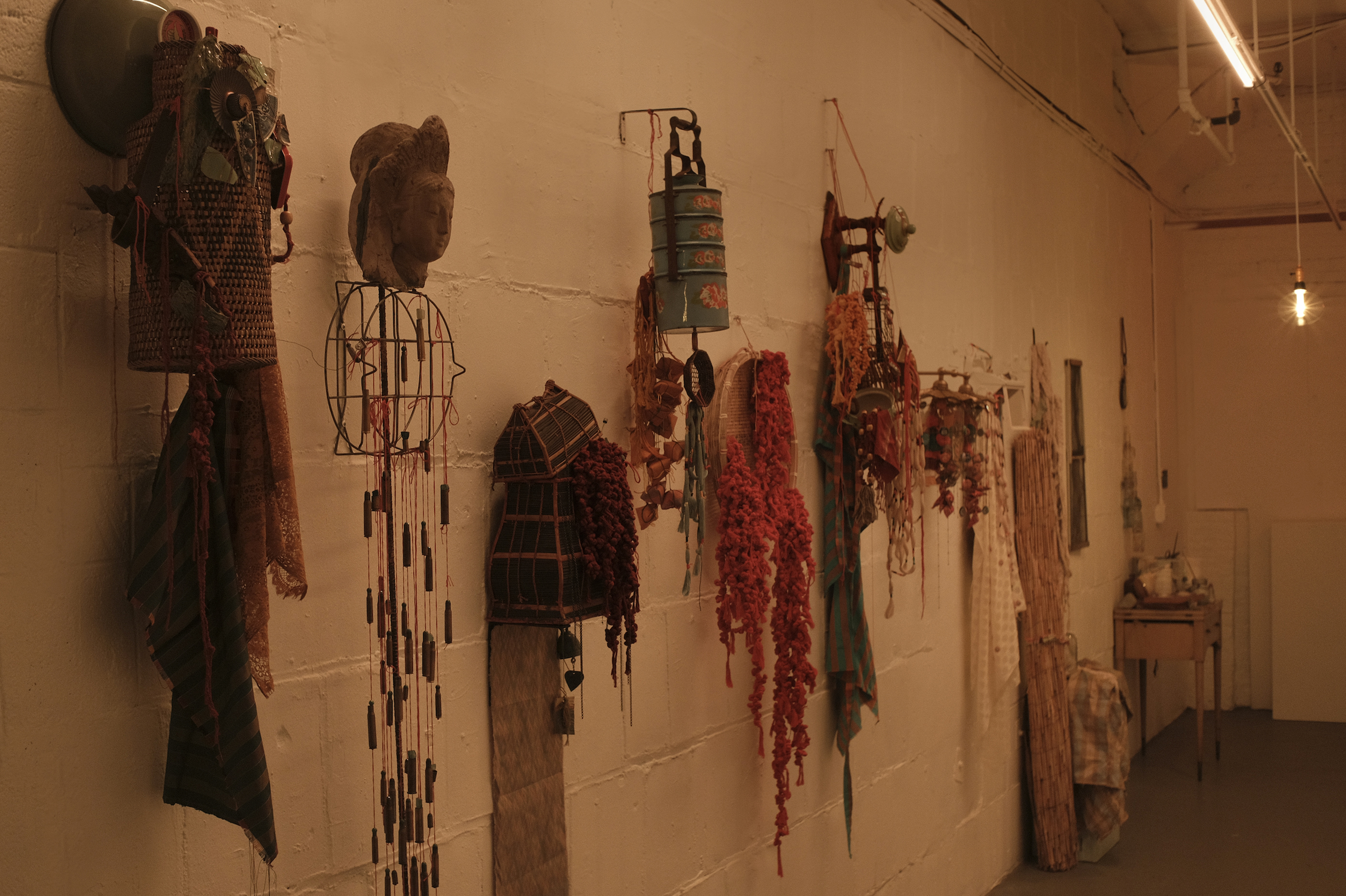 Sculptures made of found objects and woven knots hang in the MFTA gallery. 