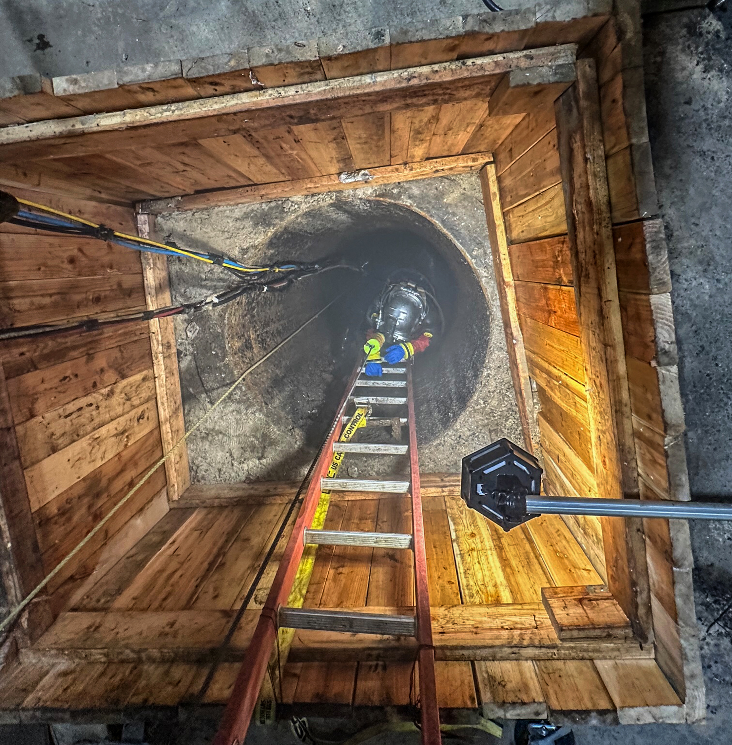 Worker Climbing down Maintenance Hole