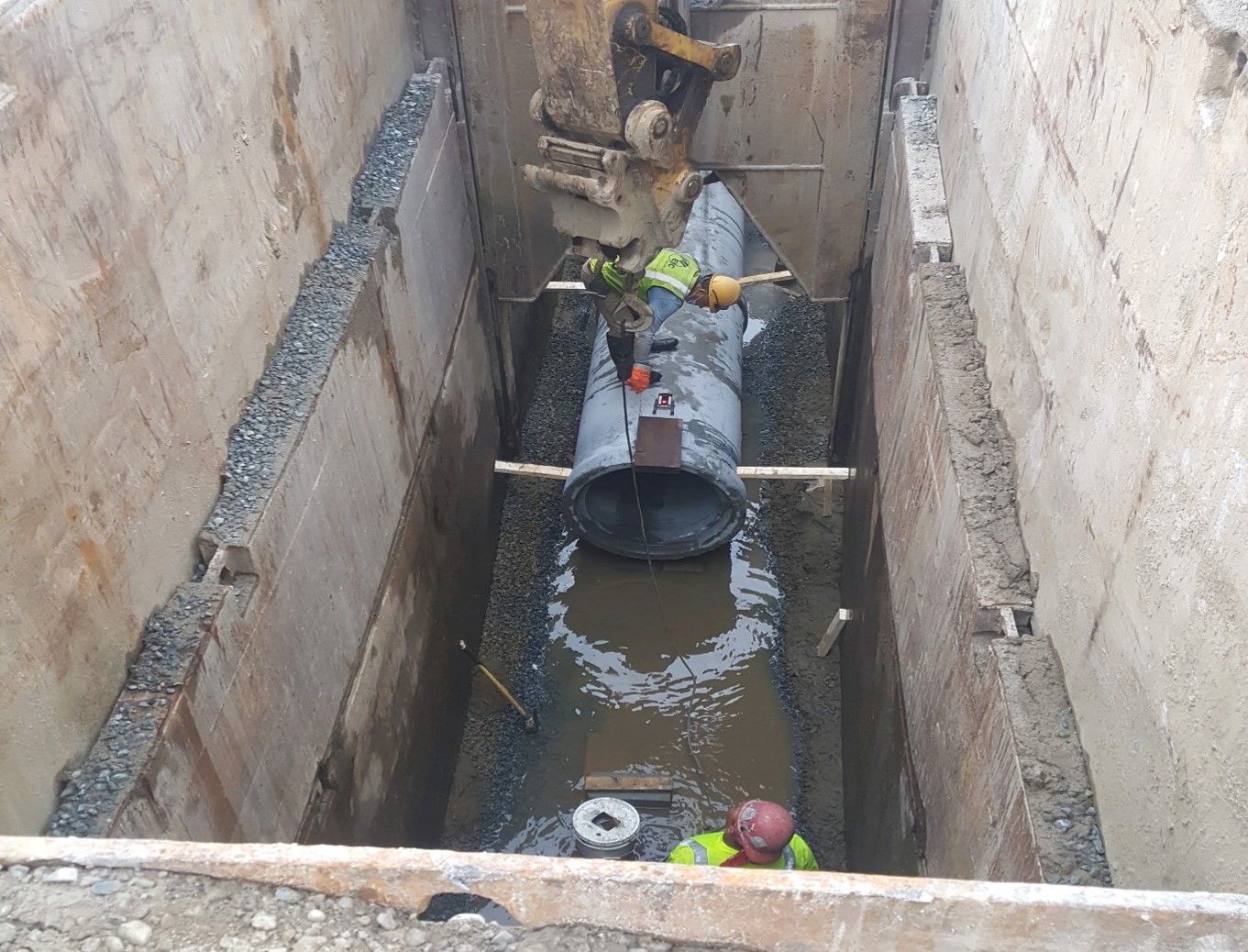 Construction crew upgrading outdated sanitary sewer pipe to 30-inch reinforced concrete pipe