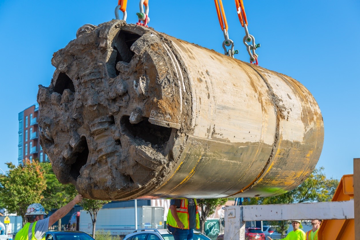 Crew lifting micro-tunneling machine that allowed for less disruption to residents in Maspeth during construction