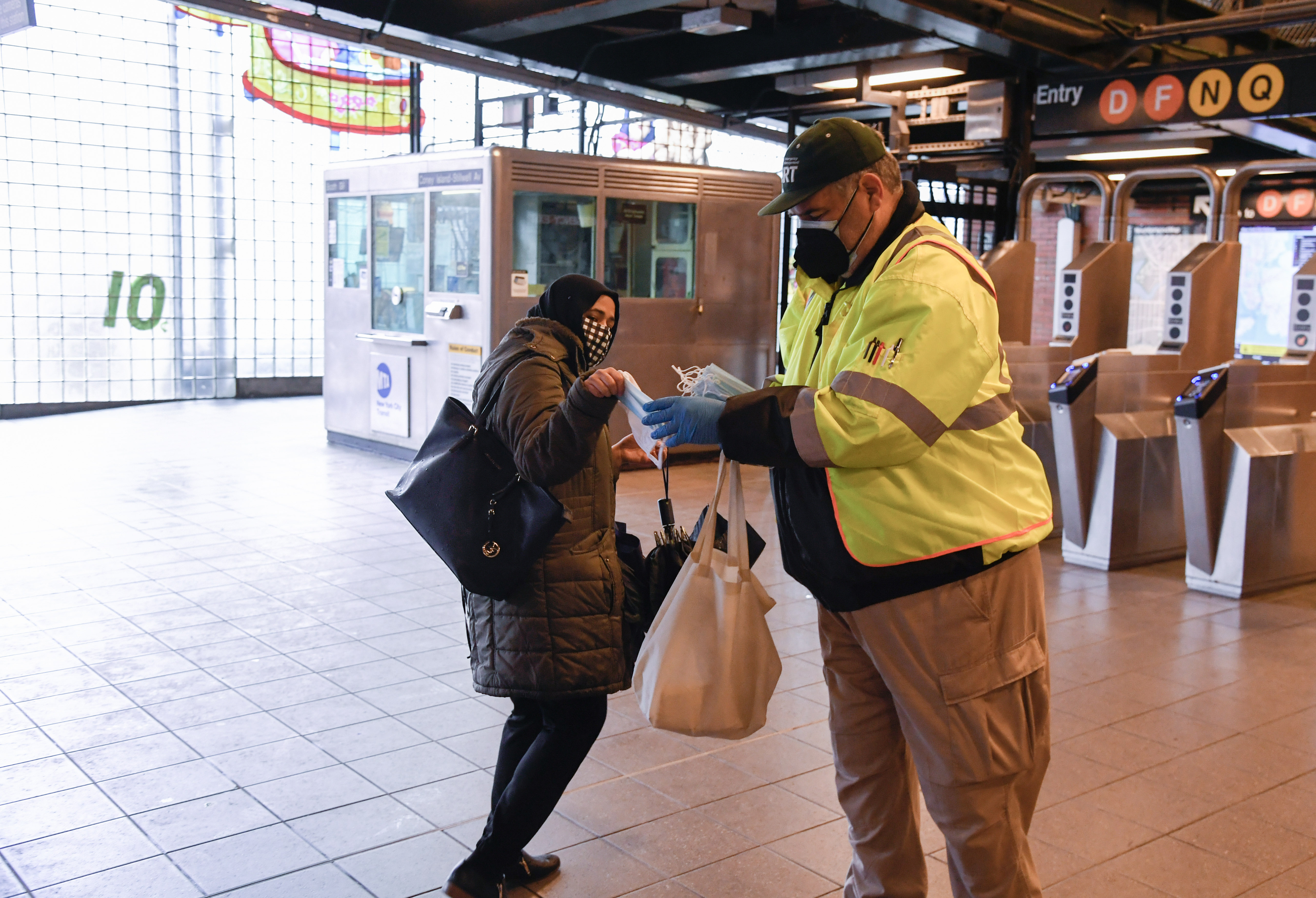 Photo of working handing out face masks at a subway station