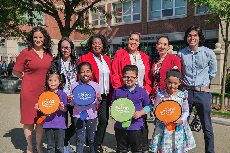 (From left to right) Debra-Ellen Glickstein, Founding Executive Director of NYC KidsRISE, Veronica Sosa, First Grade Teacher at P.S. 398Q, Commissioner Sideya Sherman, NYC Mayor's Office of Equity, Erica Urena-Thus, Founding Principle of P.S. 398Q, Lidia Jaramillo, ENL Coordinator at P.S. 398Q, Kevin Montalvo, Communications Director for Council Member Shekar Krishnan and P.S. 398Q first-grade students.