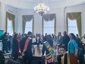 New York City Leadership and members of The Lenape Center stand for a performance by Joe Baker and Hadrien Coumans. 