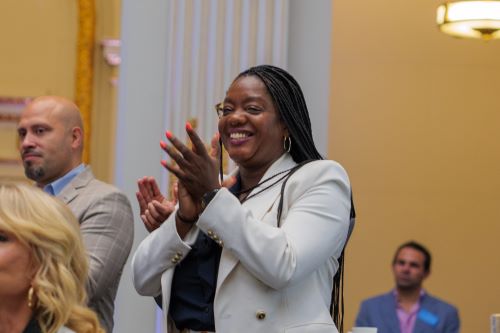 Mayor's Office of Equity Commissioner Sideya Sherman applauds in crowd.