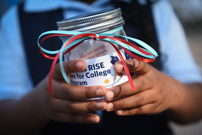 Close of a child's hands holding a donation jar