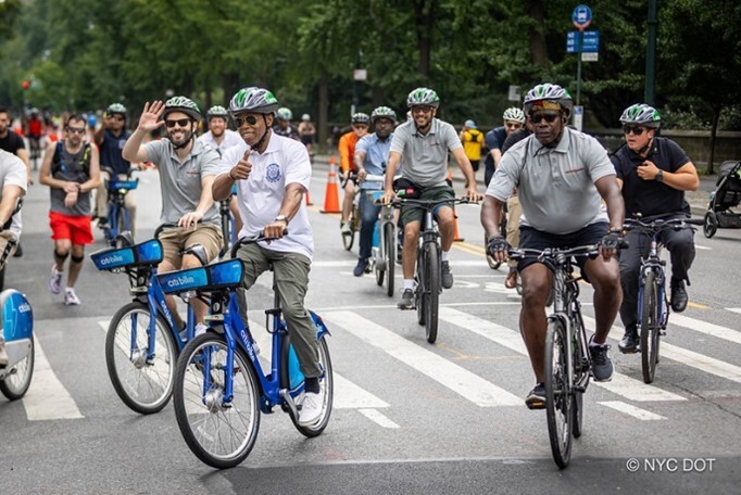 Mayor Adam is riding on Citi Bike and followed-by a crowd of biker