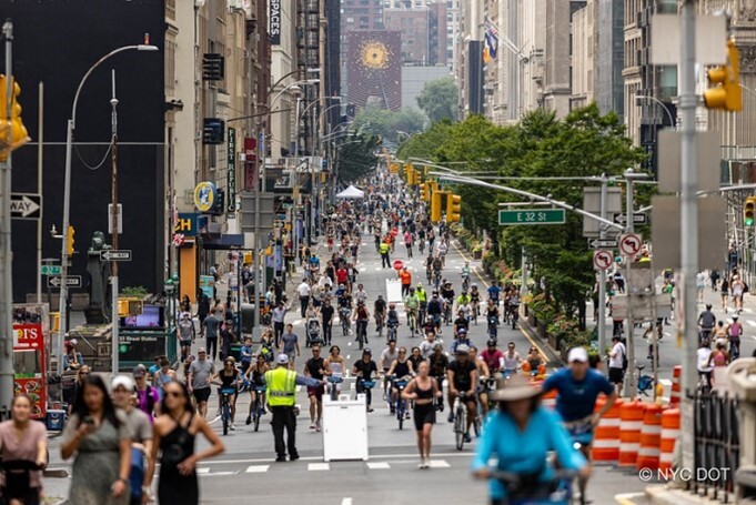 A street with a crowd of bikers in the distance.