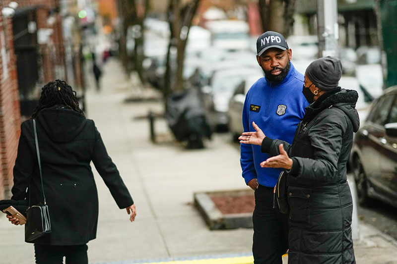 Woman talking to a man in an NYPD cap