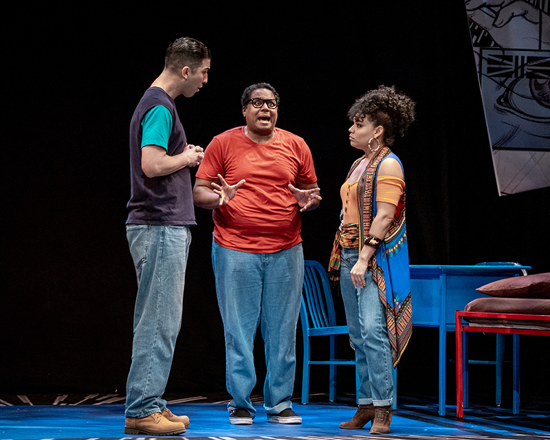 Two young men and one young woman acting on stage