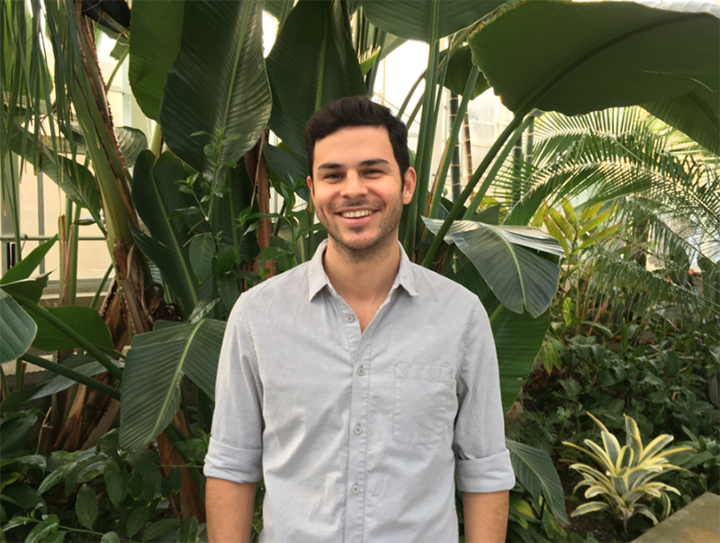 Smiling man standing in front of greenery garden