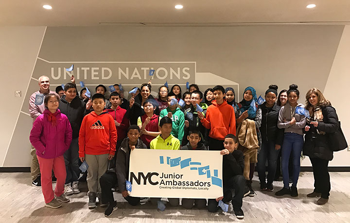 Students holding up a welcome sign
                                           