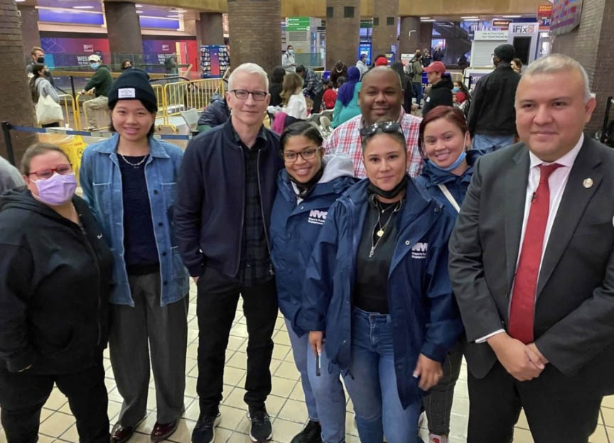 Anderson Cooper stands with PEU staffers and NYC Immigrant Affairs Commissioner Manuel Castro.