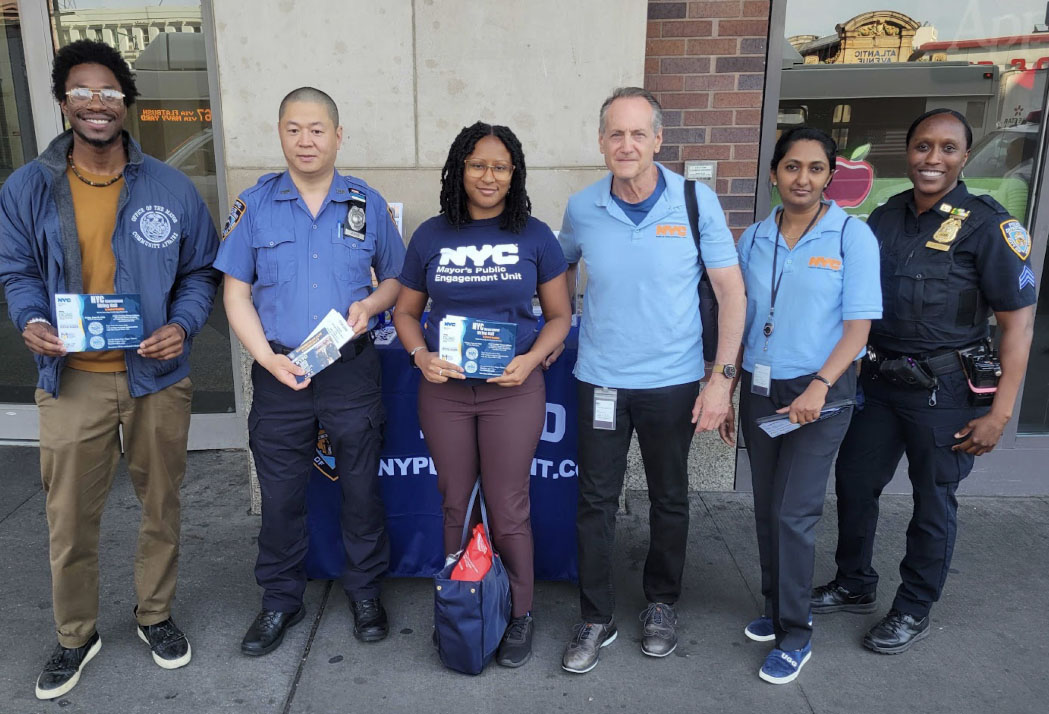 6 workers pose for a picture outdoors.