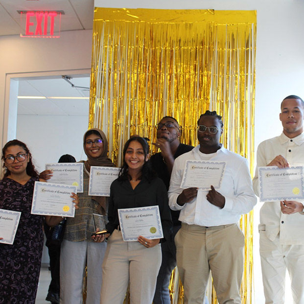 Group of interns stand as they hold their certificates.