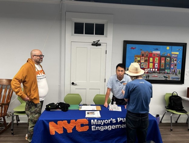 Two PEU staffers speak with someone who has stopped by their PEU table.