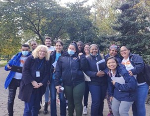 A large group of PEU staffers pose together in city park.