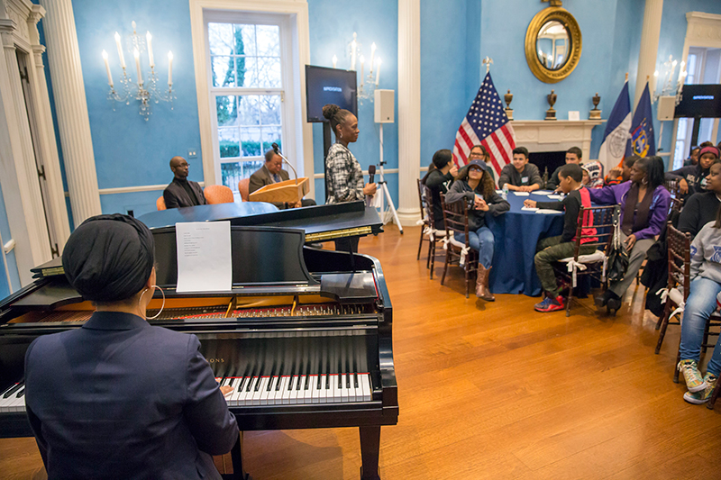 First Lady Chirlane McCray standing in front of children at Jazz improvisation workshop