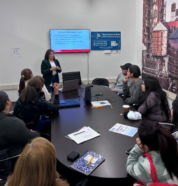 •	Program Coordinator Jenny Proaño gives an intimate partner violence training in Spanish to a conference room of clients