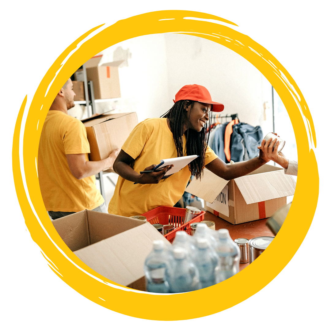 Photo of two people smiling while packing donation boxes