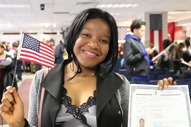 A new American citizen smiling at ceremony