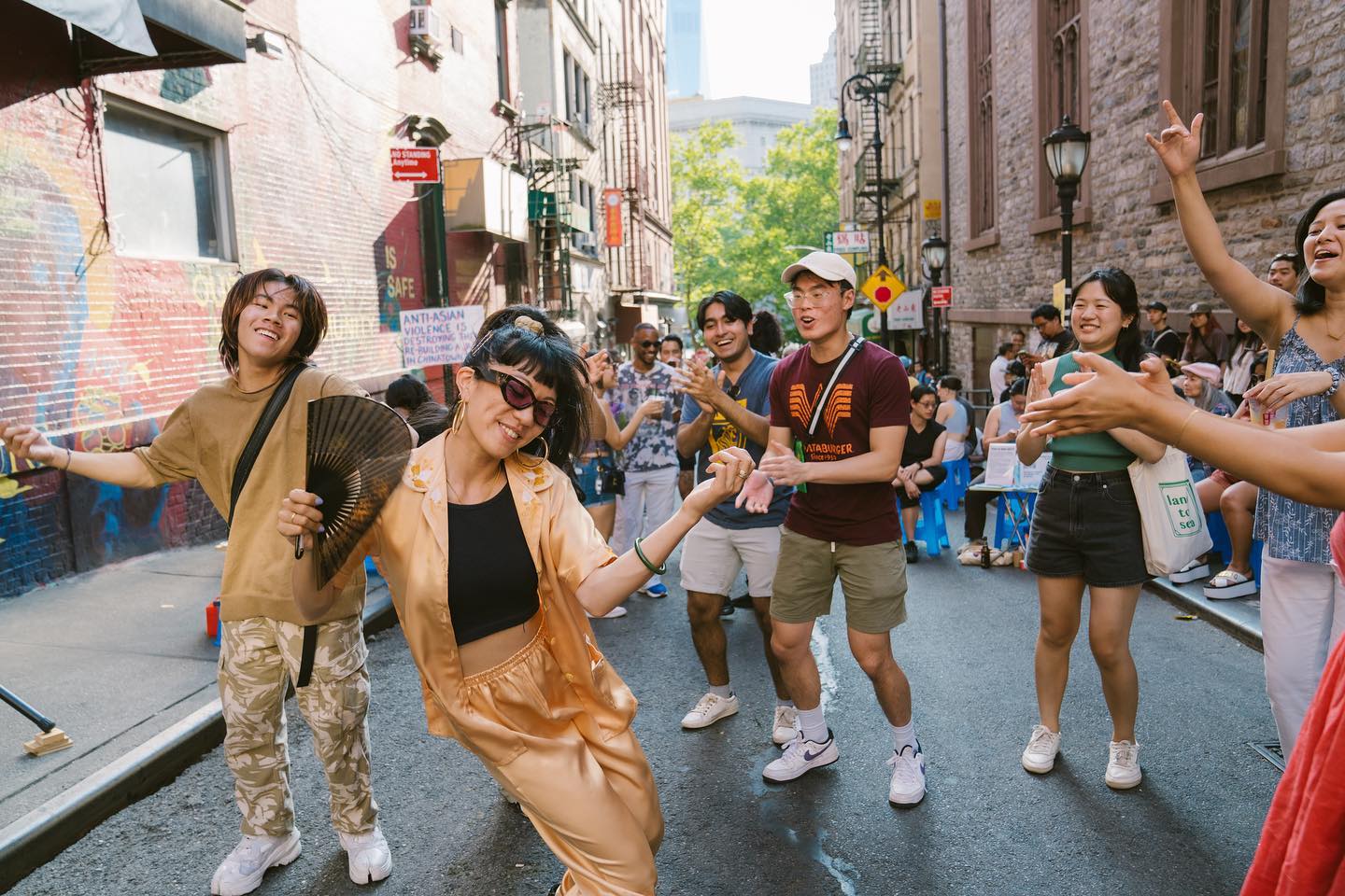 group of people dancing in the street at a party in Chinatown