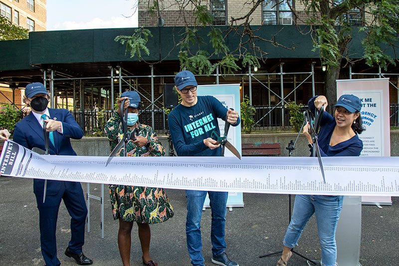 4 people cutting a ribbon that reads internet bill