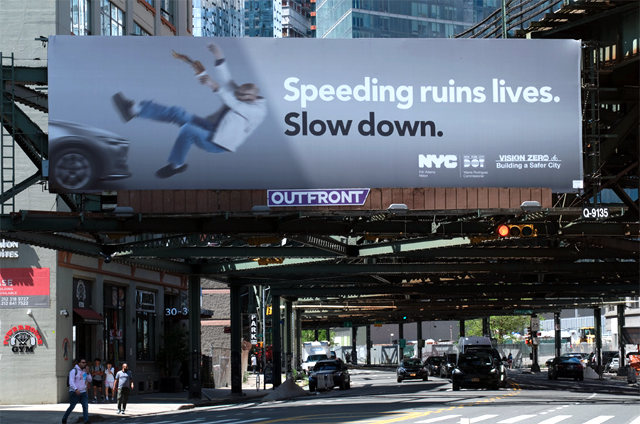 Billboard in Long Island City reads, Speeding ruins lives. Slow down, with an image of a person hit by a car.