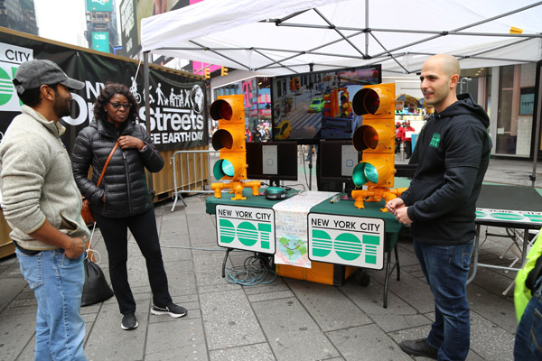 People stand next to a table and tent in Times Square to talk about traffic signals and NYC DOT