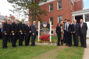 FDNY members and the family of Charles Evans in front of the Charles Evans Fire Safety Education Building. (L to R) FDNY Chaplain Rabbi Joseph Potasnik, Chief of Training Thomas Galvin, Chief of Department Edward Kilduff, First Deputy Commissioner Don Shacknai, Fire Commissioner Salvatore Cassano, Evans' sister and member of the Charles Evans Foundation Alice Shure, Mr. Evans' wife Bonnie Evans, Tony Shure, Charles Evans, Jr., FDNY Foundation Board Member Nicholas Scoppetta and Chairman of the FDNY Foundation Board Steve Ruzow.